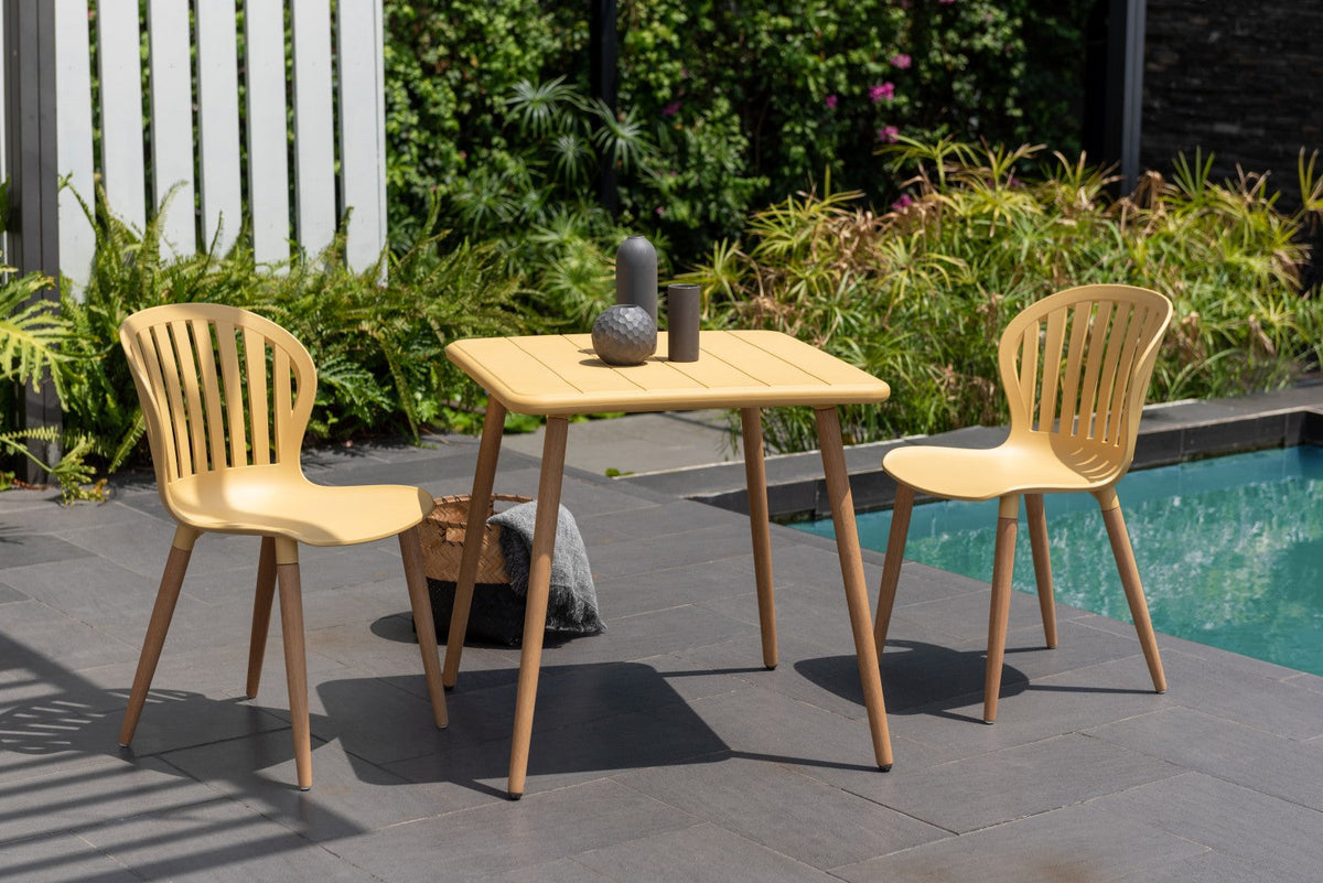 Nassau Square Table Honey Yellow Social Plastic outdoor table with two chairs by a pool on Tampa Home & Garden Store