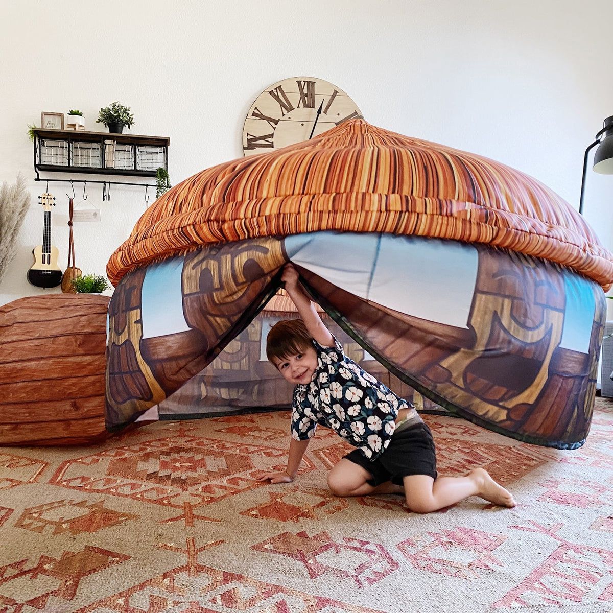 AirFort Tiki Hut inflatable kids play fort with orange striped canopy and tiki walls kid peeking on Tampa Home & Garden Store