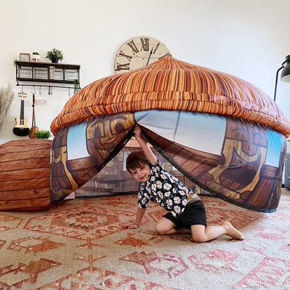 AirFort Tiki Hut inflatable kids play fort with orange striped canopy and tiki walls kid peeking on Tampa Home & Garden Store