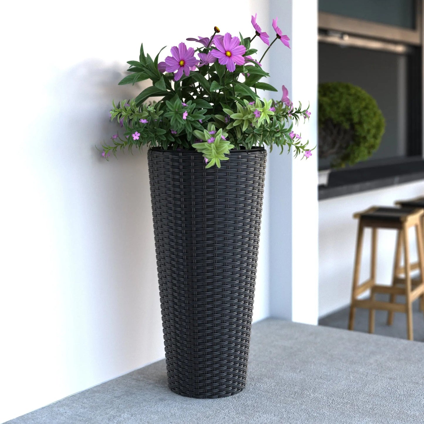 Noah Round Wicker Planter 2-piece Set in Black with purple flowers and green foliage on a white wall on Tampa Home & Garden Store