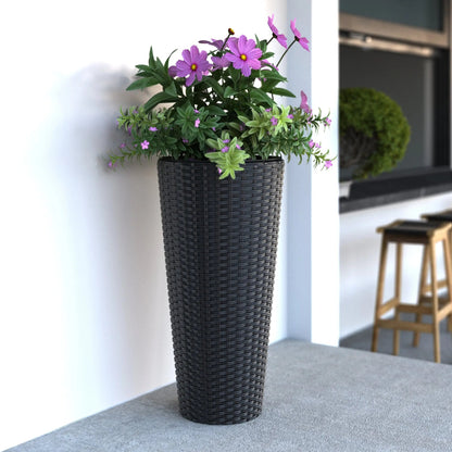 Noah Round Wicker Planter 2-piece Set in Black with purple flowers and green foliage on a white wall on Tampa Home & Garden Store