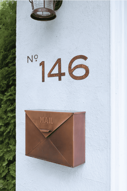 Rustic house number 146 copper finish mounted on a light stucco wall with copper mailbox on Tampa Home & Garden Store