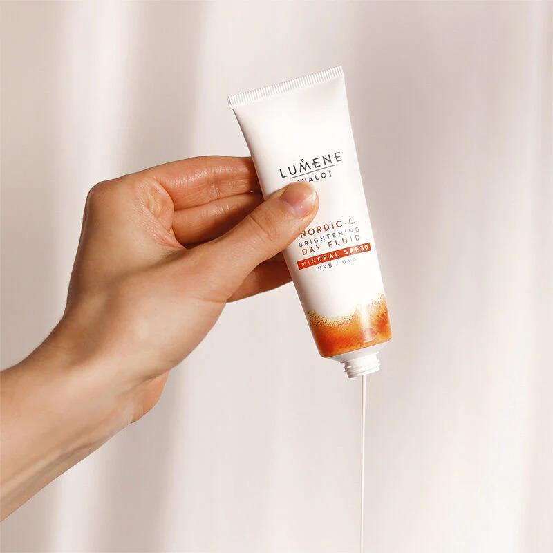 Lumene SPF30 face cream tube, white with orange bottom held in hand on Tampa Home & Garden Store
