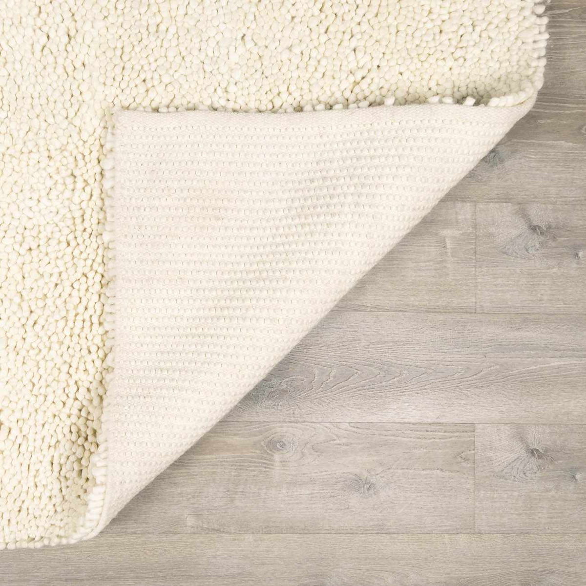 Oakridge Area Rug by Boutique Rugs, cream boucle shag on light wood floor on Tampa Home & Garden Store
