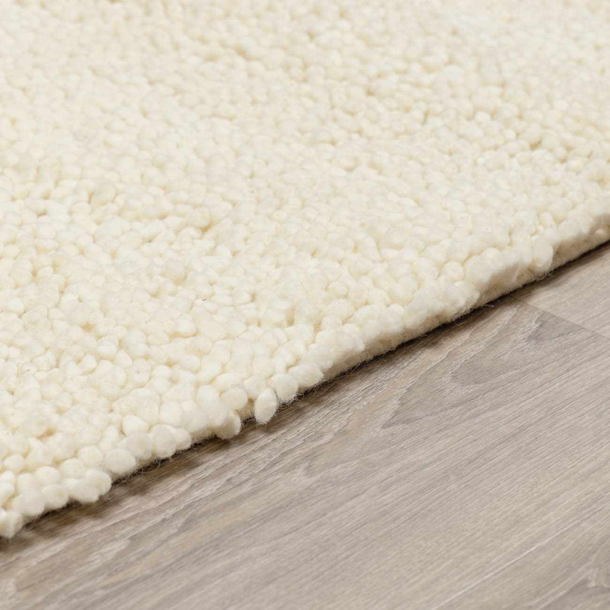 Oakridge Area Rug ivory boucle pile close-up edge on light wood floor Boutique Rugs on Tampa Home & Garden Store