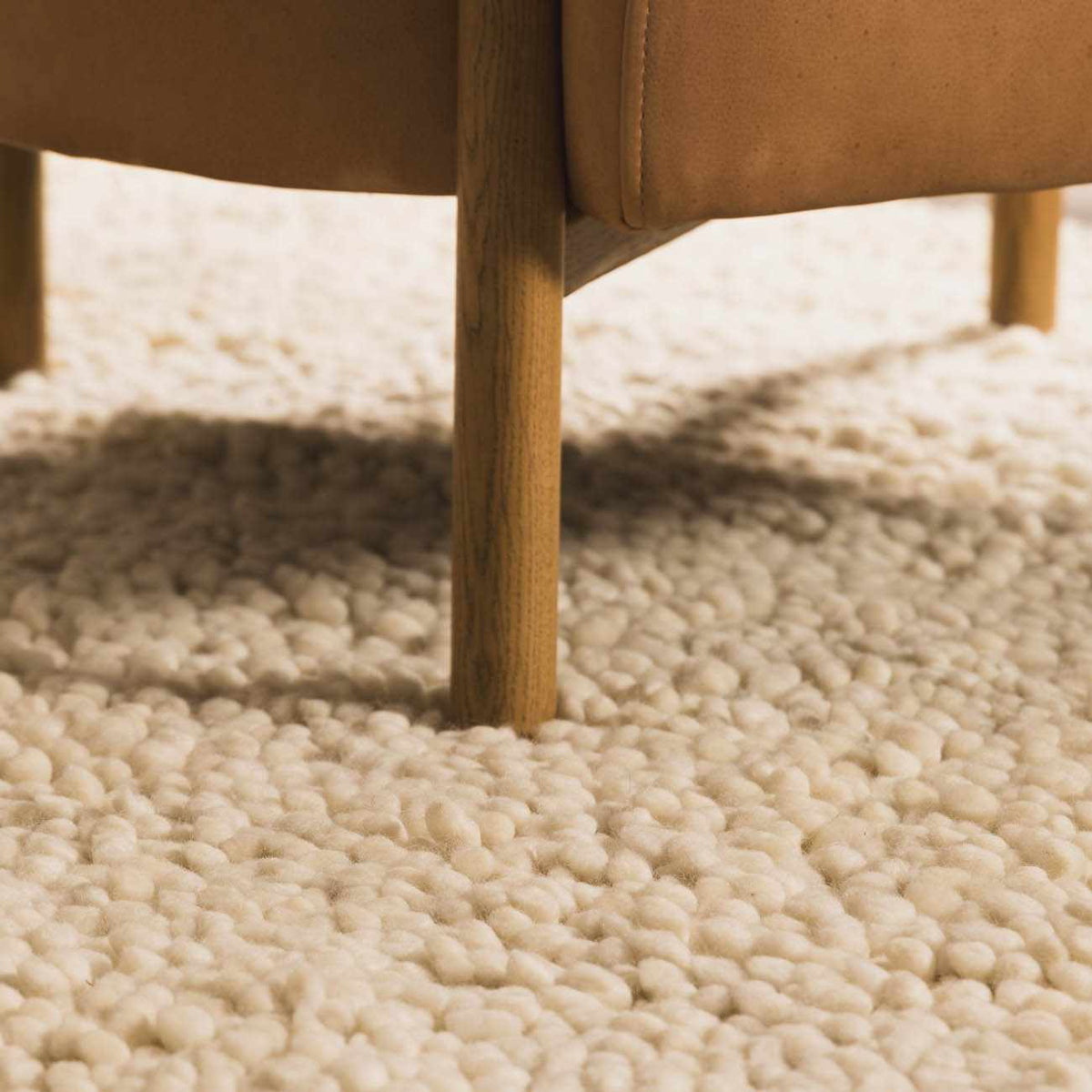 Oakridge Area Rug by Boutique Rugs, cream shag under a wooden chair leg on Tampa Home & Garden Store