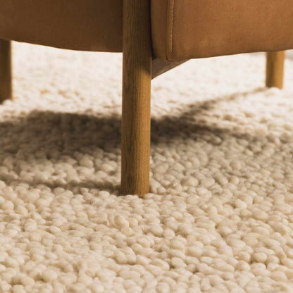Oakridge Area Rug by Boutique Rugs, cream shag under a wooden chair leg on Tampa Home & Garden Store