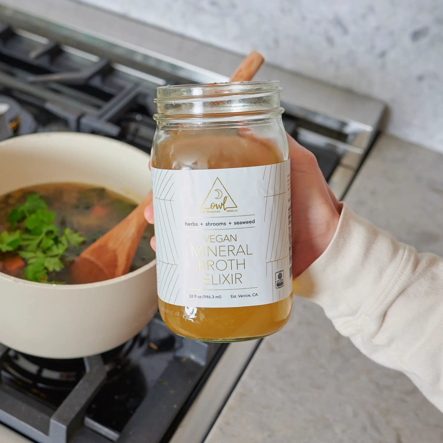 OWL Venice vegan mineral broth elixir jar with cinnamon stick and herbs visible in kitchen on Tampa Home & Garden Store