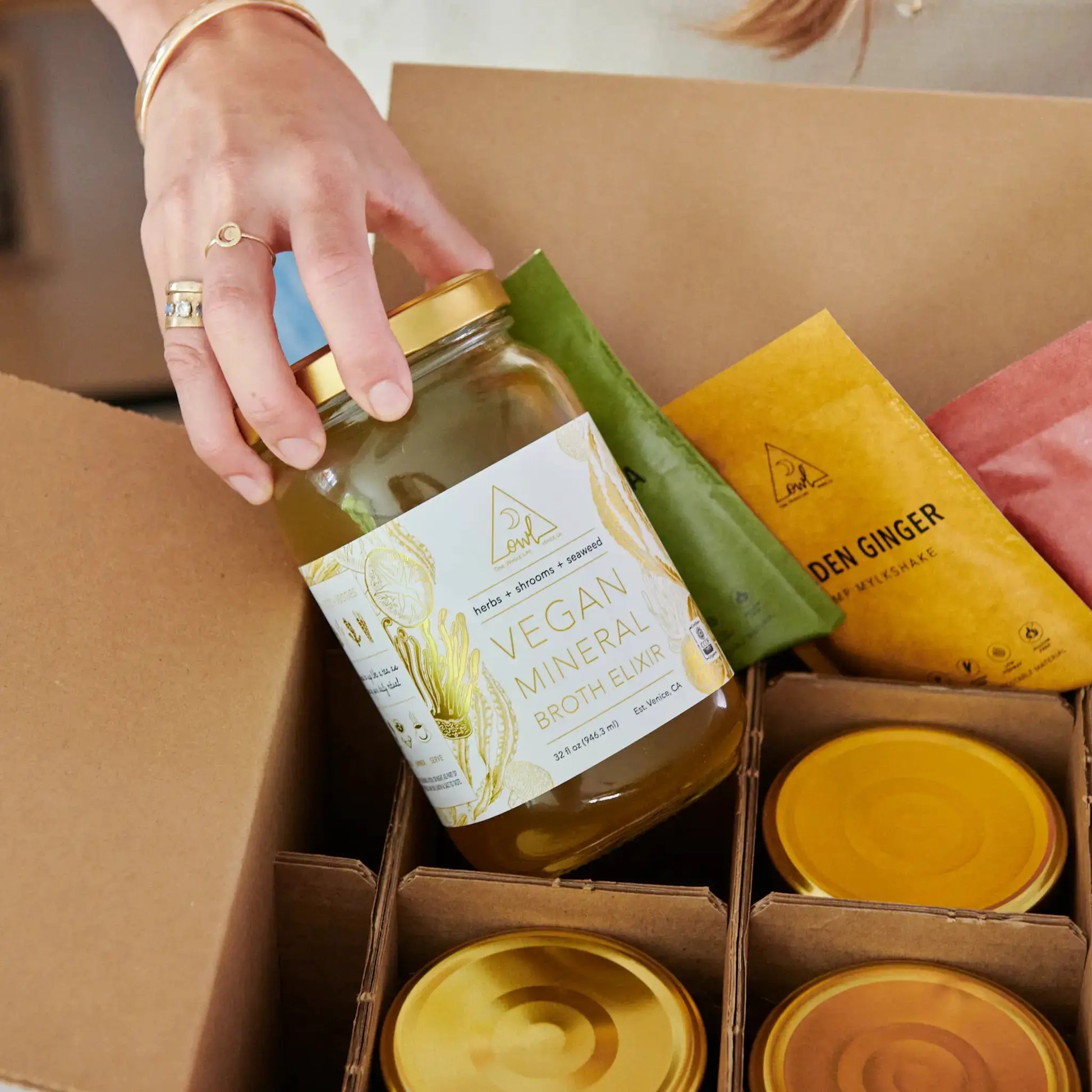 OWL Reset Organic Cleanse jars by OWL Venice; clear glass bottles with gold lids among boxed products on Tampa Home & Garden Store