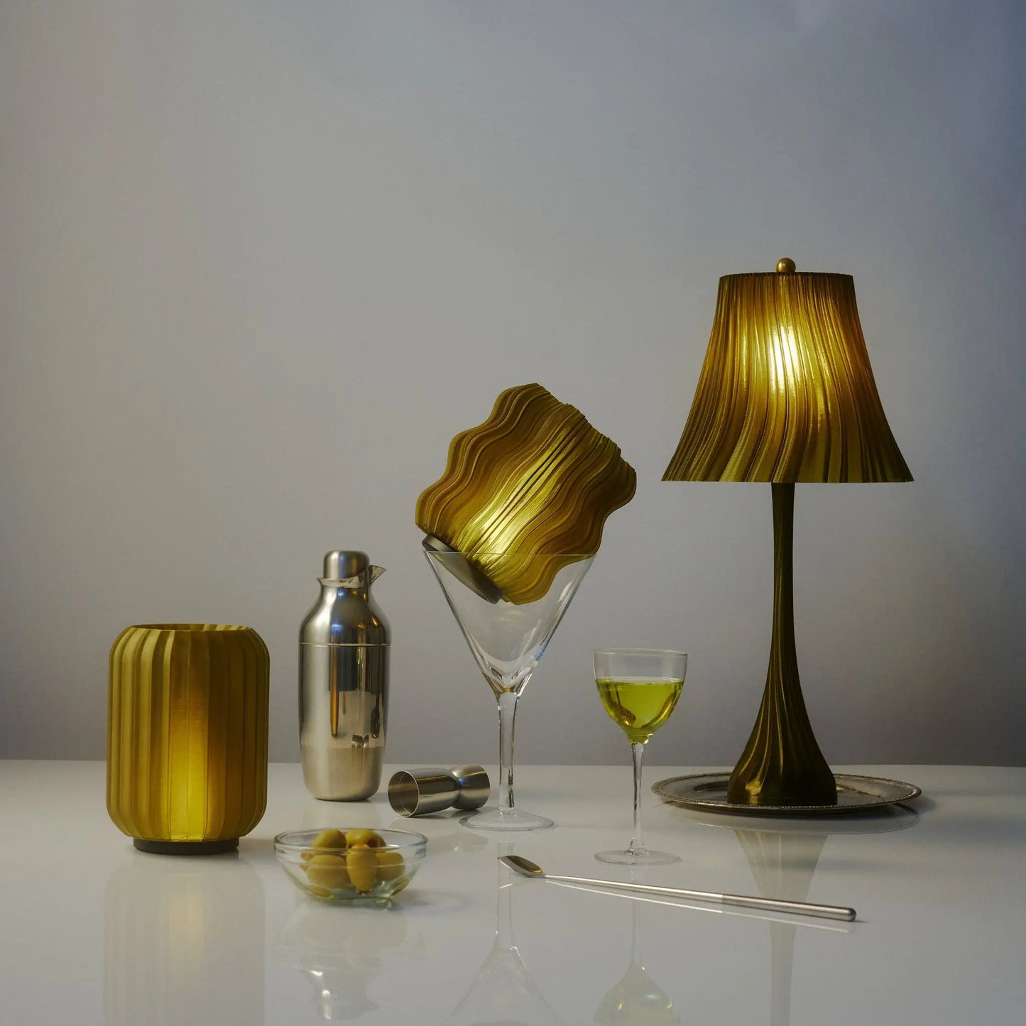 Mini Allium cordless table lamp Wooj Design in gold ribbed finish with glassware on surface on Tampa Home & Garden Store