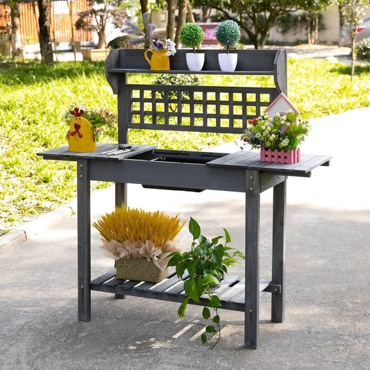Outdoor grey wood potting bench with expandable top, features yellow watering can and white pots on Tampa Home & Garden Store