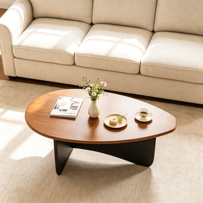 Oval coffee table with warm wood top and black curved base, mid-century modern low-profile on Tampa Home & Garden Store