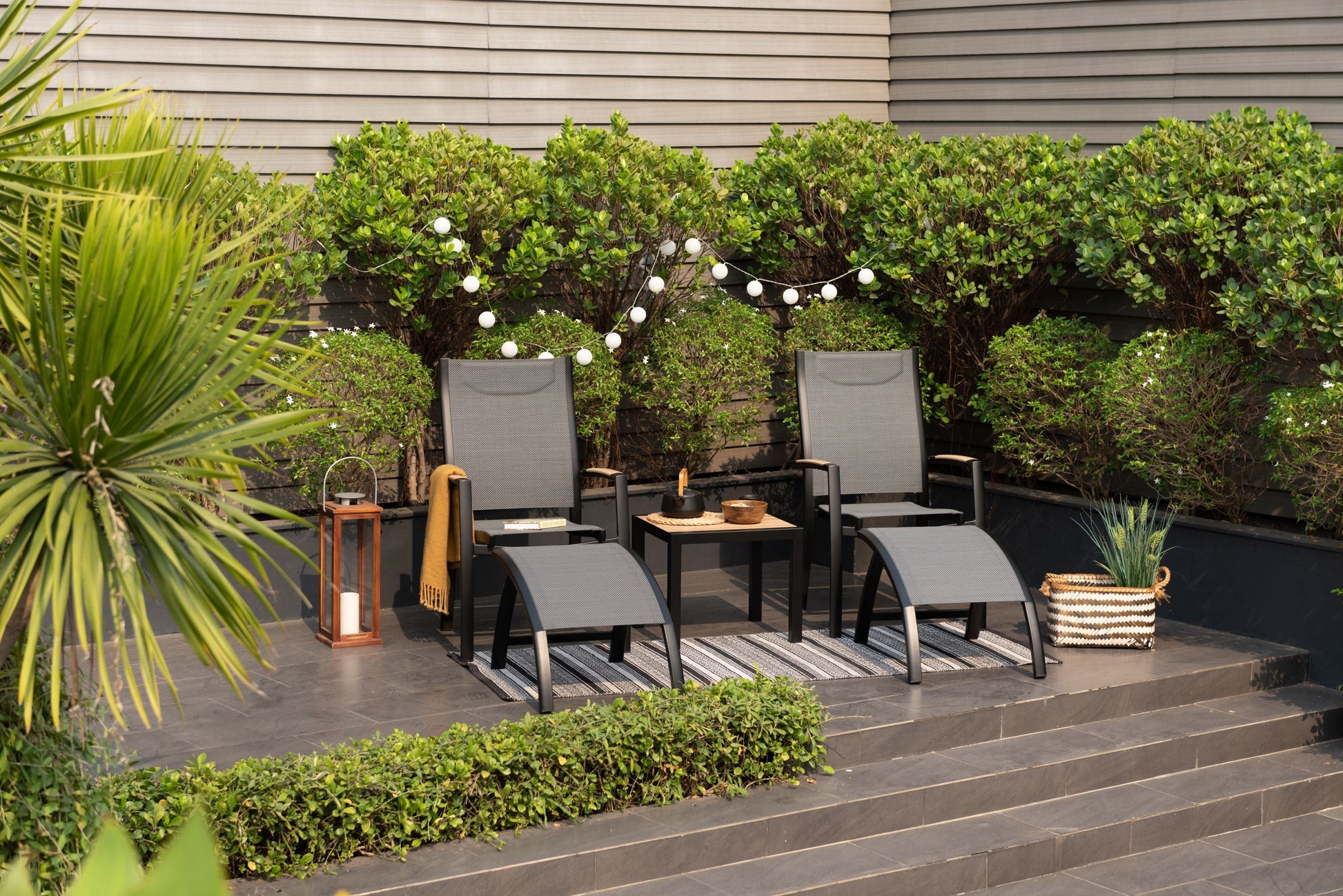 Panama Dark Side Tables, two black-framed tables with wooden tops beside gray woven chairs on Tampa Home & Garden Store