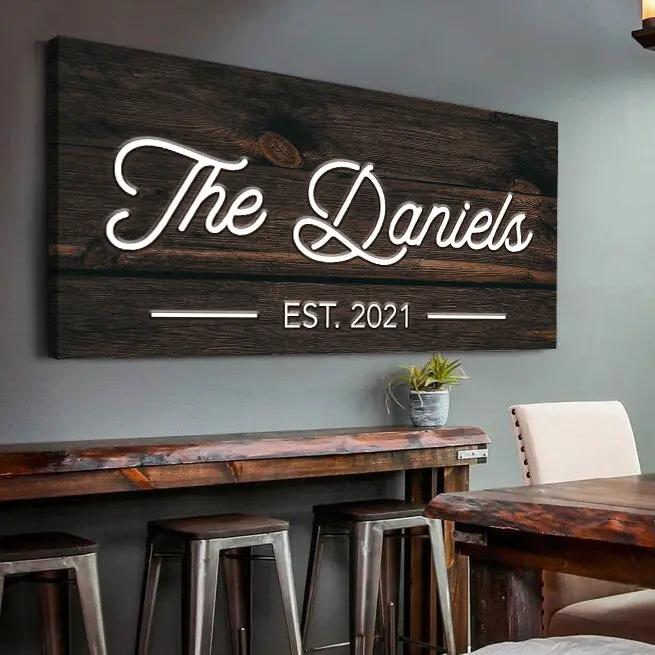 Wooden family name sign on dark wood planks with white script The Daniels EST. 2021 on Tampa Home & Garden Store