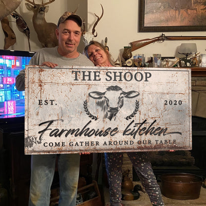 Farmhouse Kitchen Sign canvas with distressed cream finish and black script held by couple on Tampa Home & Garden Store