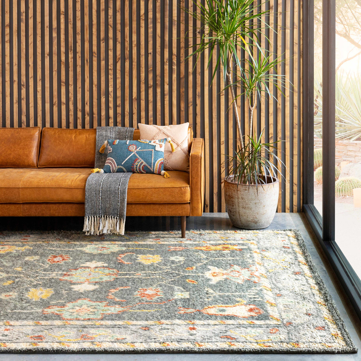 Prosperidad Handmade Wool Rug with grey base and multicolor accents in a modern living room on Tampa Home & Garden Store