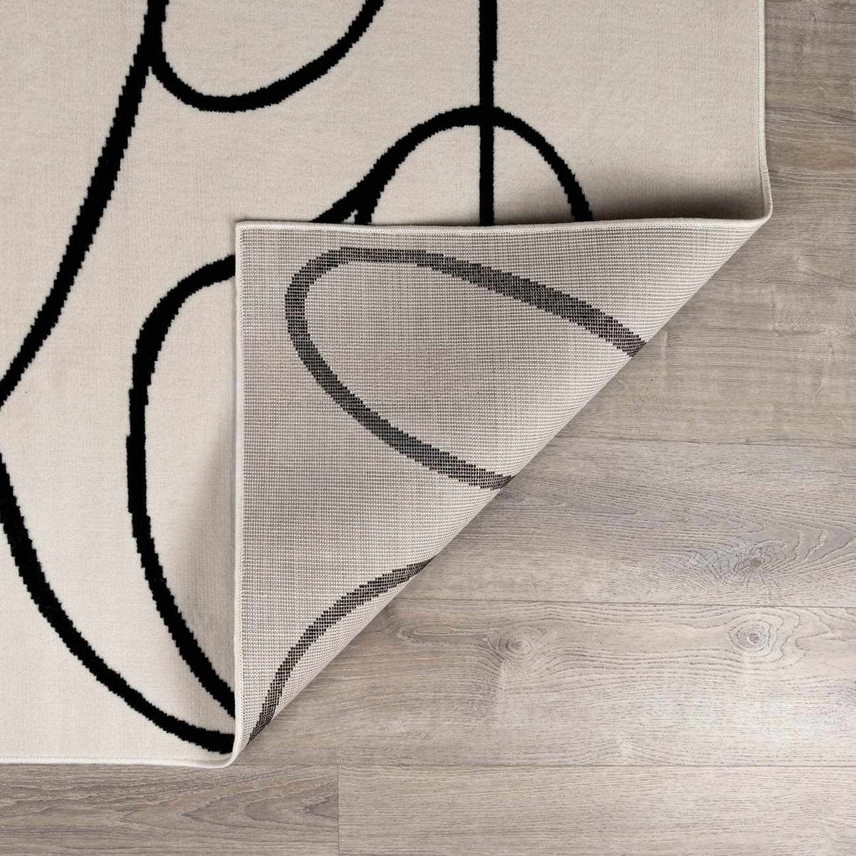 Eilir Modern Low Profile Boho Rug beige with black abstract loop pattern, tight weave on Tampa Home & Garden Store