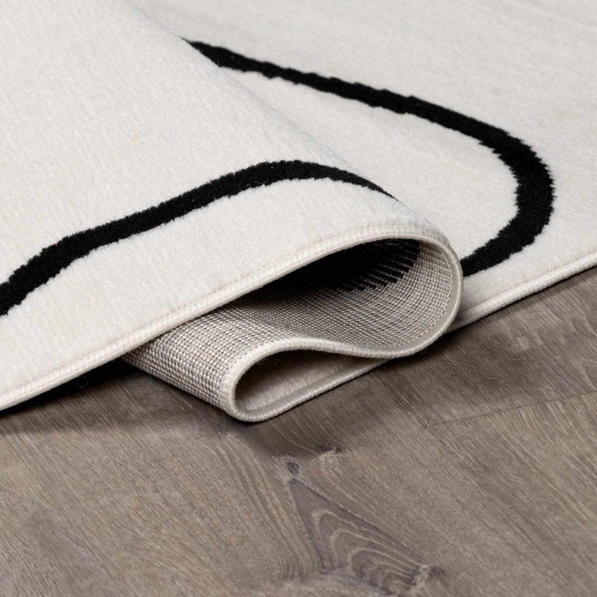 Eilir Modern Low Profile Boho Rug white with black curved stripe, rolled underside Boutique Rugs on Tampa Home & Garden Store