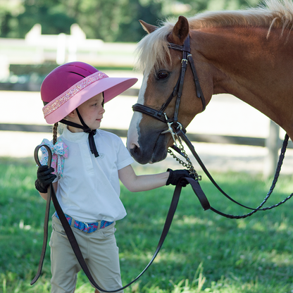 EquiVisor Glitz sun visor in pink with glitter band worn by child beside a horse on Tampa Home & Garden Store