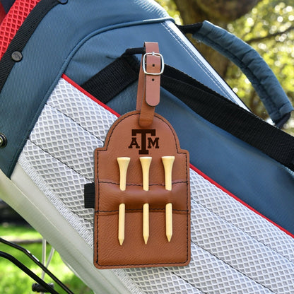 Texas A&M leather golf tee holder with tan leather strap and three wooden tees on blue bag on Tampa Home & Garden Store