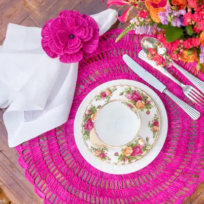 Buriti straw placemats magenta round woven under a floral plate with napkin on wood on Tampa Home & Garden Store
