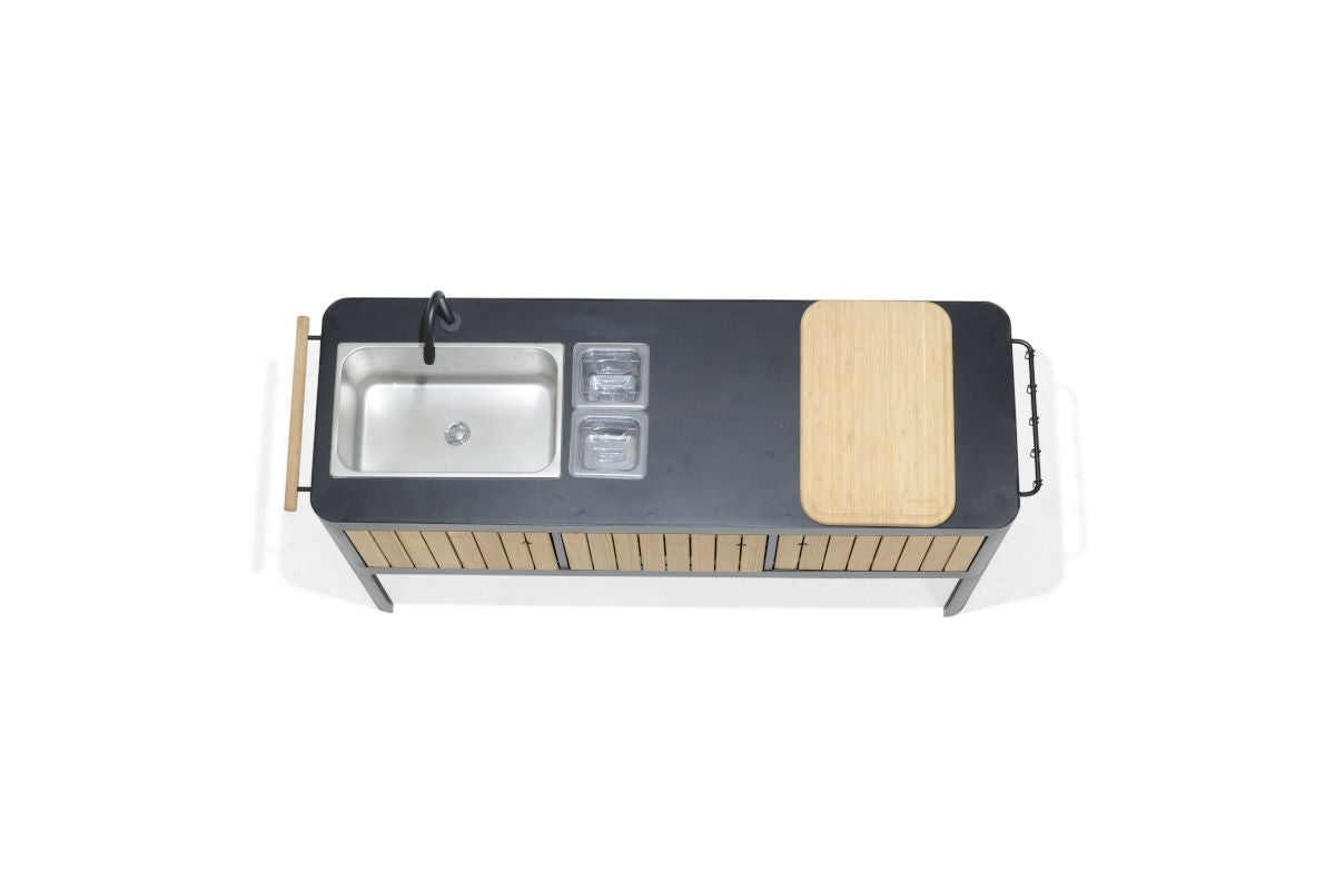 Portals dark outdoor kitchen island with black countertop, stainless sink, and cutting board on Tampa Home & Garden Store