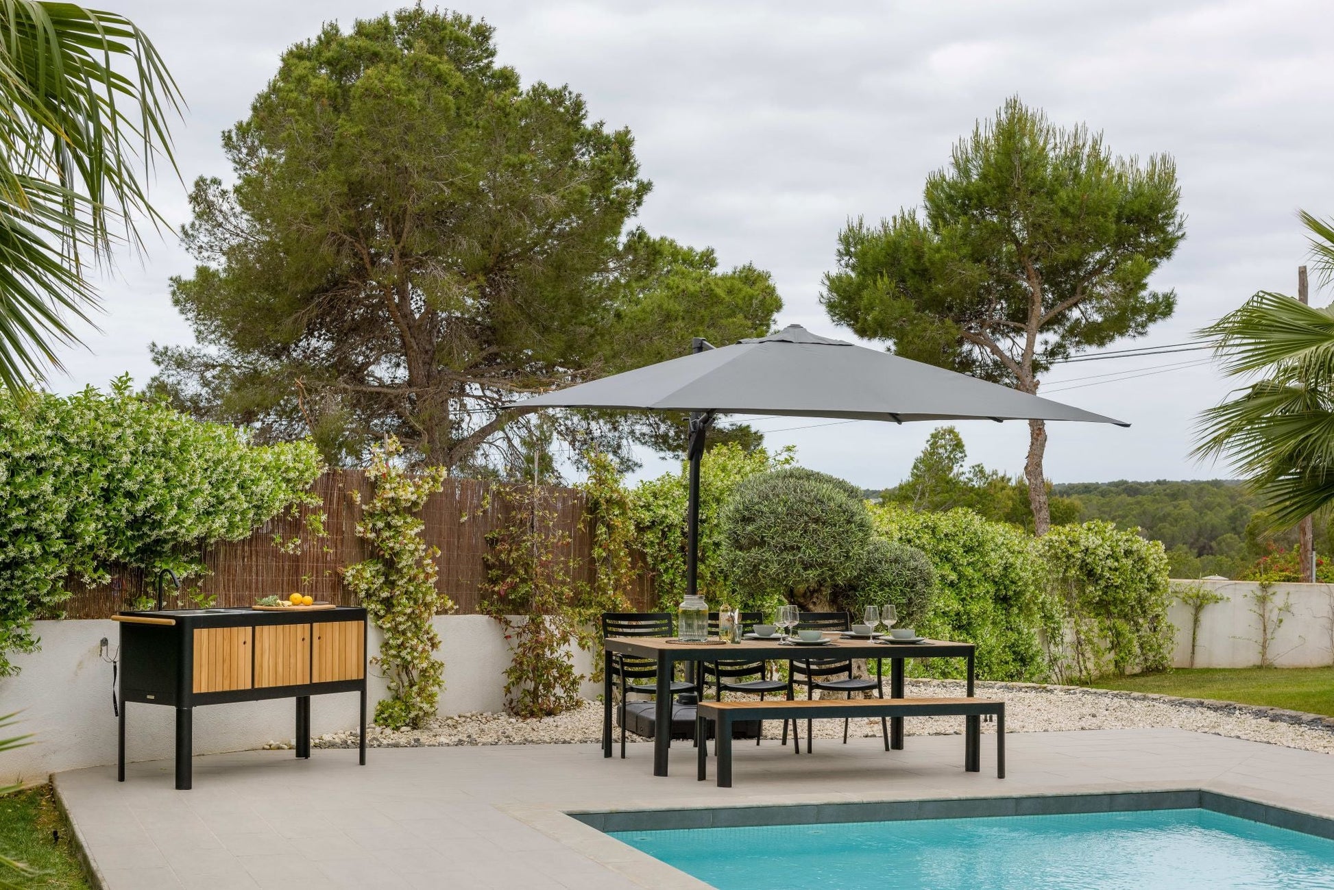 Portals teak and aluminum picnic bench by LifestyleGarden in gray dining set beside pool on Tampa Home & Garden Store