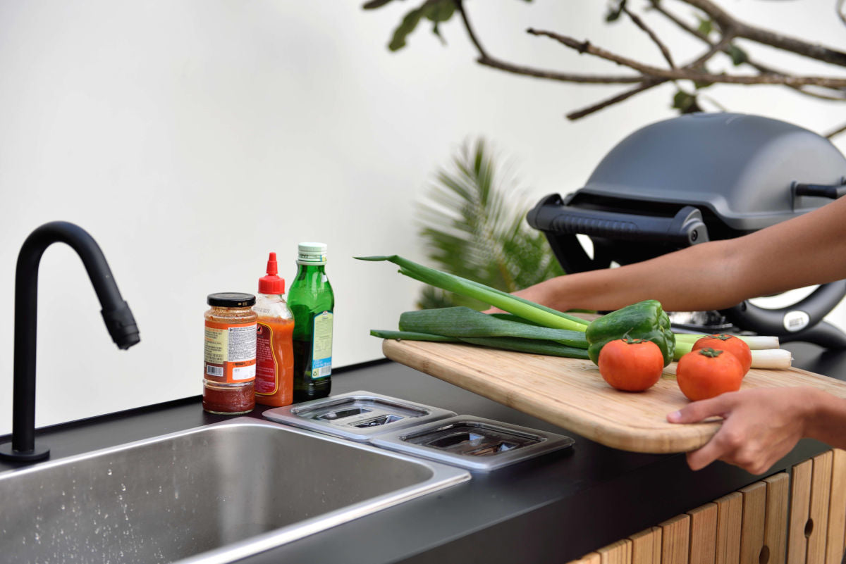 Portals Dark Outdoor Kitchen island with black countertop, sink, and veggie cutting board on Tampa Home & Garden Store