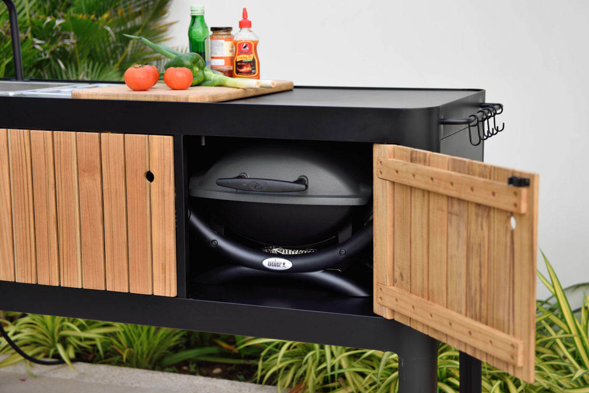 Portals Dark Outdoor Kitchen with a black metal frame and wood slat doors, built-in Weber grill on Tampa Home & Garden Store