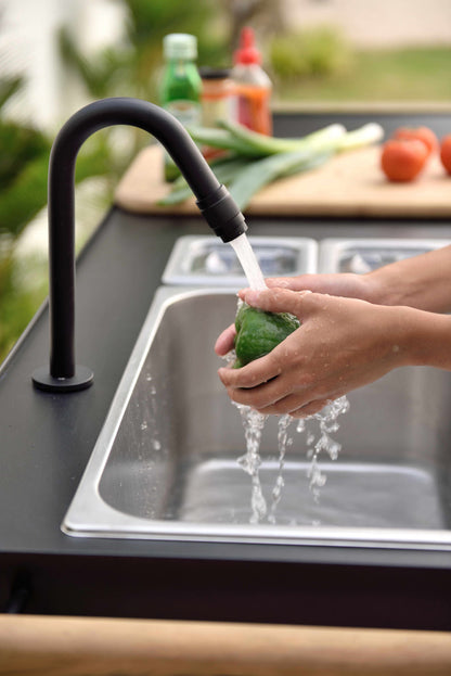 Portals Dark Outdoor Kitchen black curved faucet over stainless sink washing a green pepper on Tampa Home & Garden Store