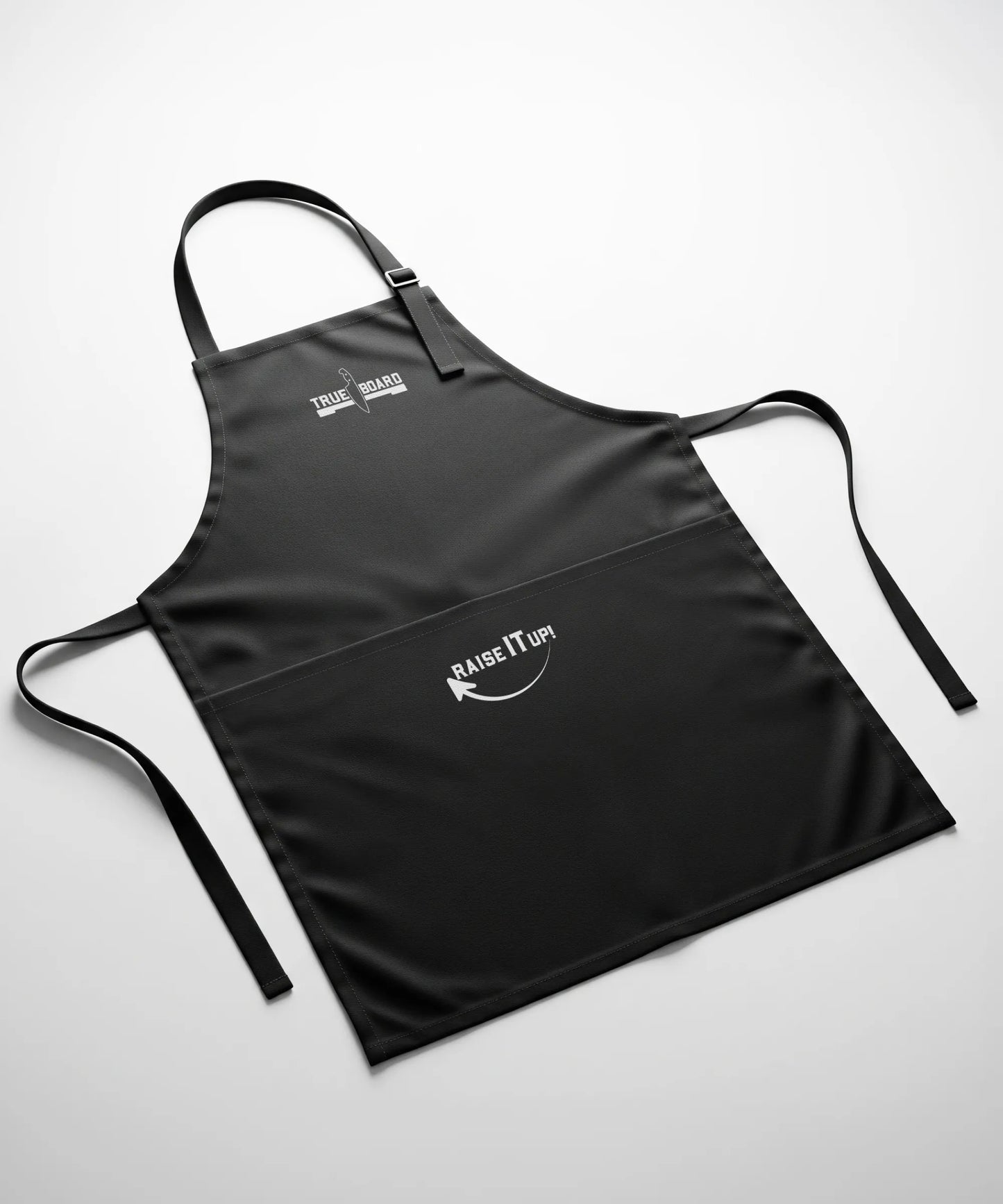 True Board apron in black with white logo and Raise It Up graphic; adjustable neck strap on Tampa Home & Garden Store