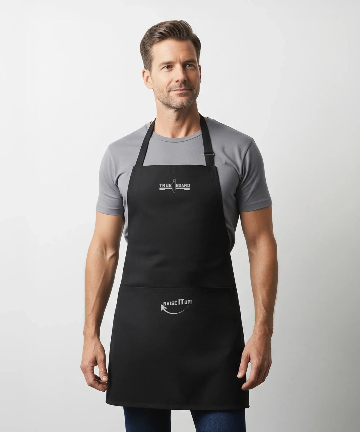 True Board Apron black with logo, adjustable neck strap worn by male model on Tampa Home & Garden Store