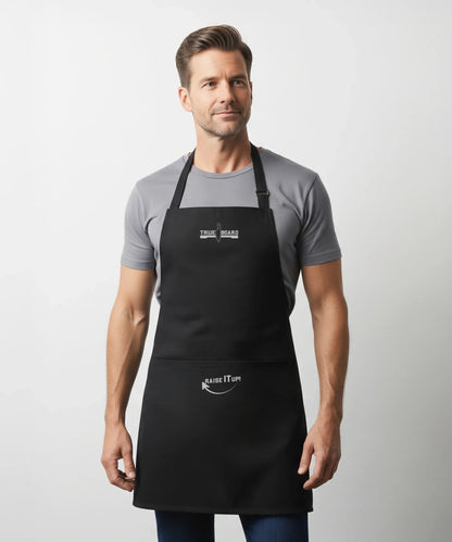 True Board Apron black with logo, adjustable neck strap worn by male model on Tampa Home & Garden Store