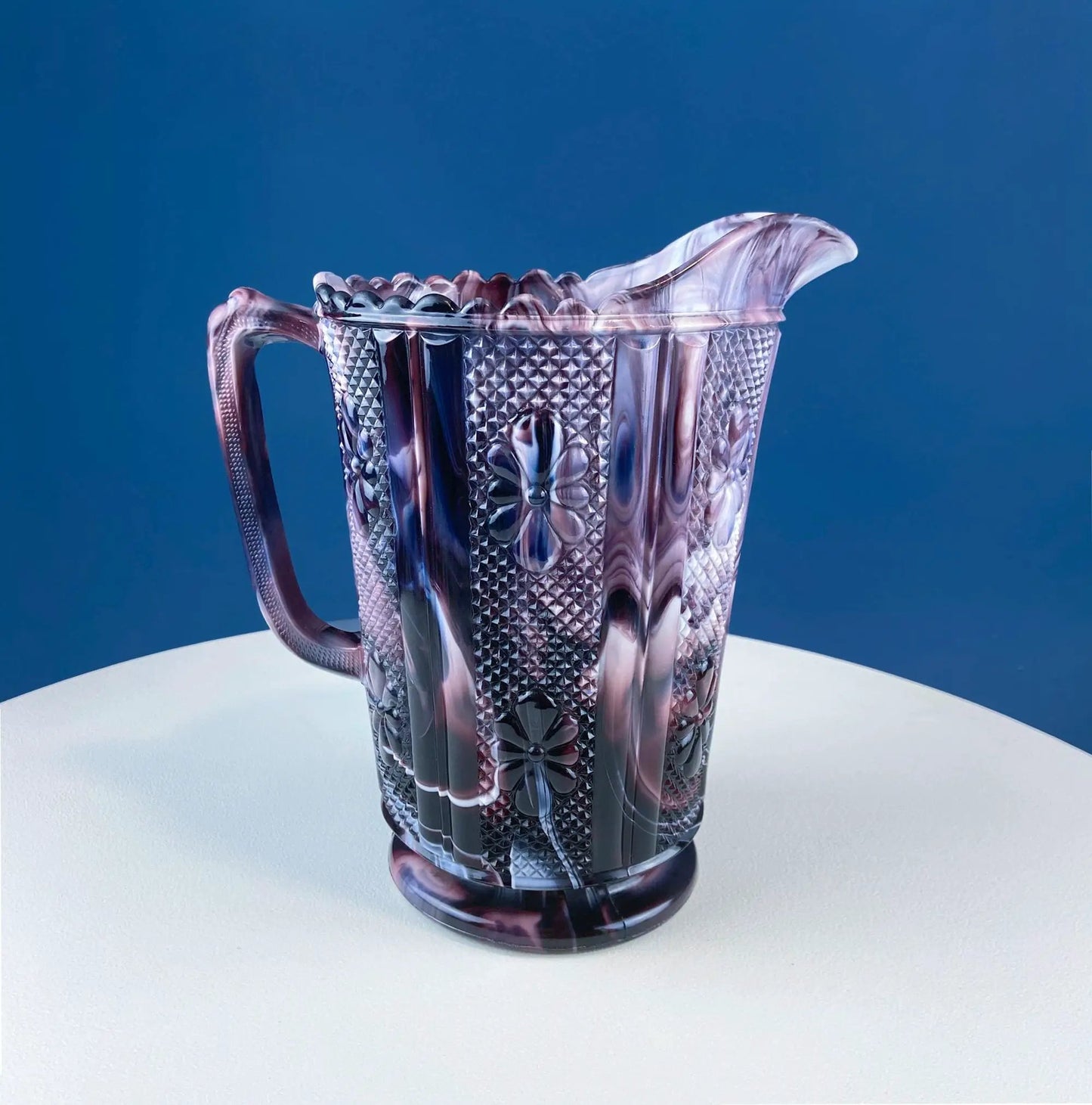 Purple slag glass milk pitcher with geometric diamond pattern and scalloped rim on Tampa Home & Garden Store