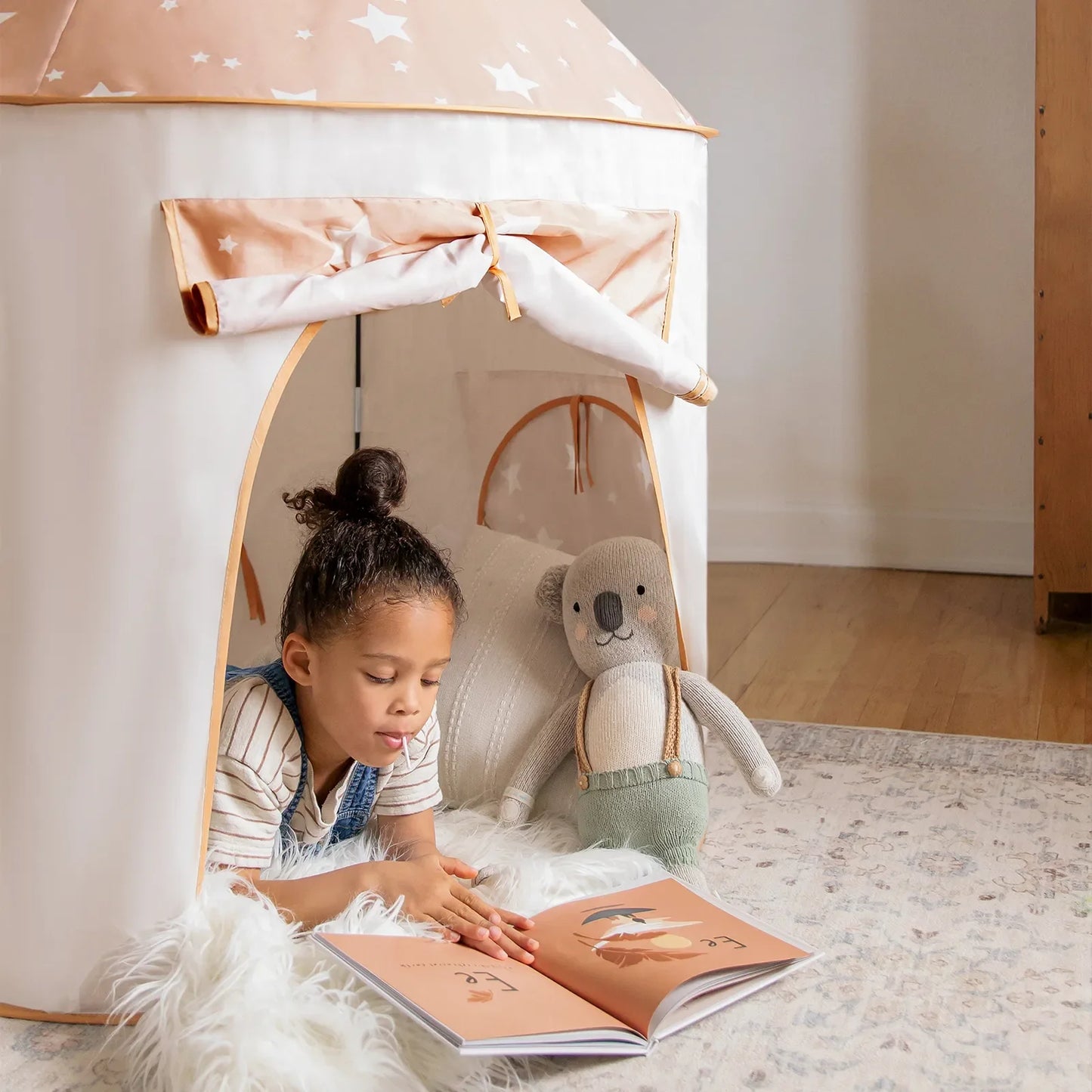 Tiny Land Compact Adventure 3-in-1 Play Tunnel peach star print child reads near plush bear on Tampa Home & Garden Store
