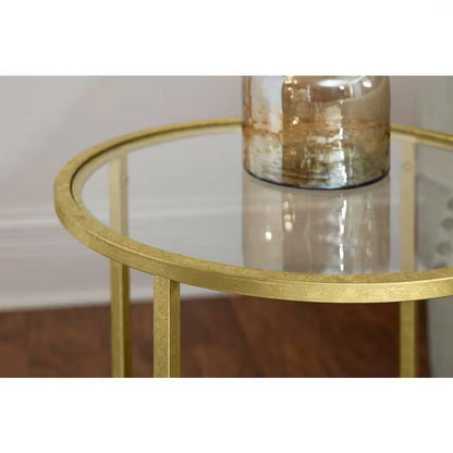 Mesa auxiliar redonda con acento, metal dorado, tapa de cristal, estante inferior.