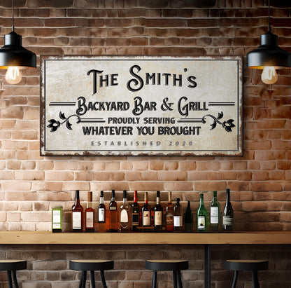 Backyard Bar & Grill Sign canvas with vintage text and frame against brick wall with bottles on Tampa Home & Garden Store