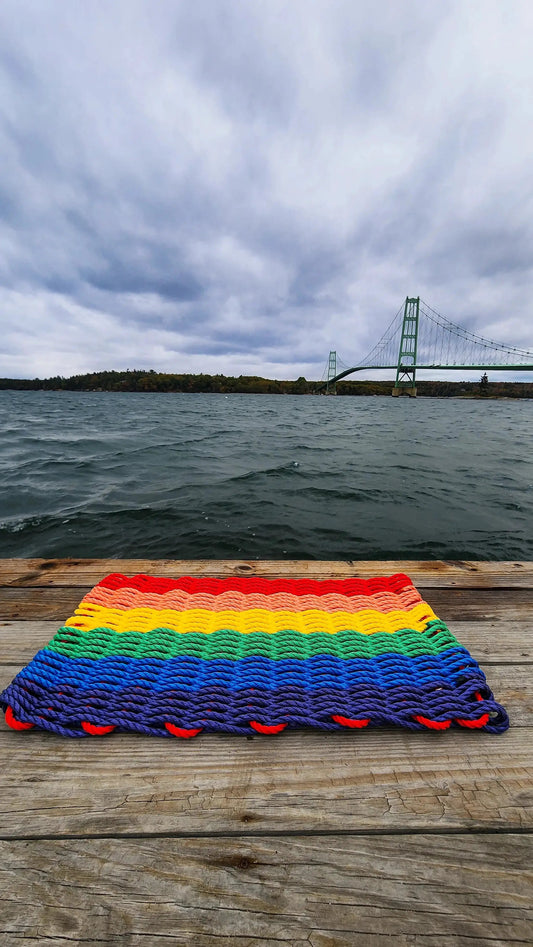 Rainbow Lobster Rope Welcome Mat by Little Salty Rope; rainbow striped rope doormat on a wooden dock on Tampa Home & Garden Store