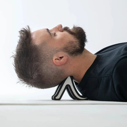 Full Body System muscle release tool in black and white with curved handles used on a man's neck on Tampa Home & Garden Store