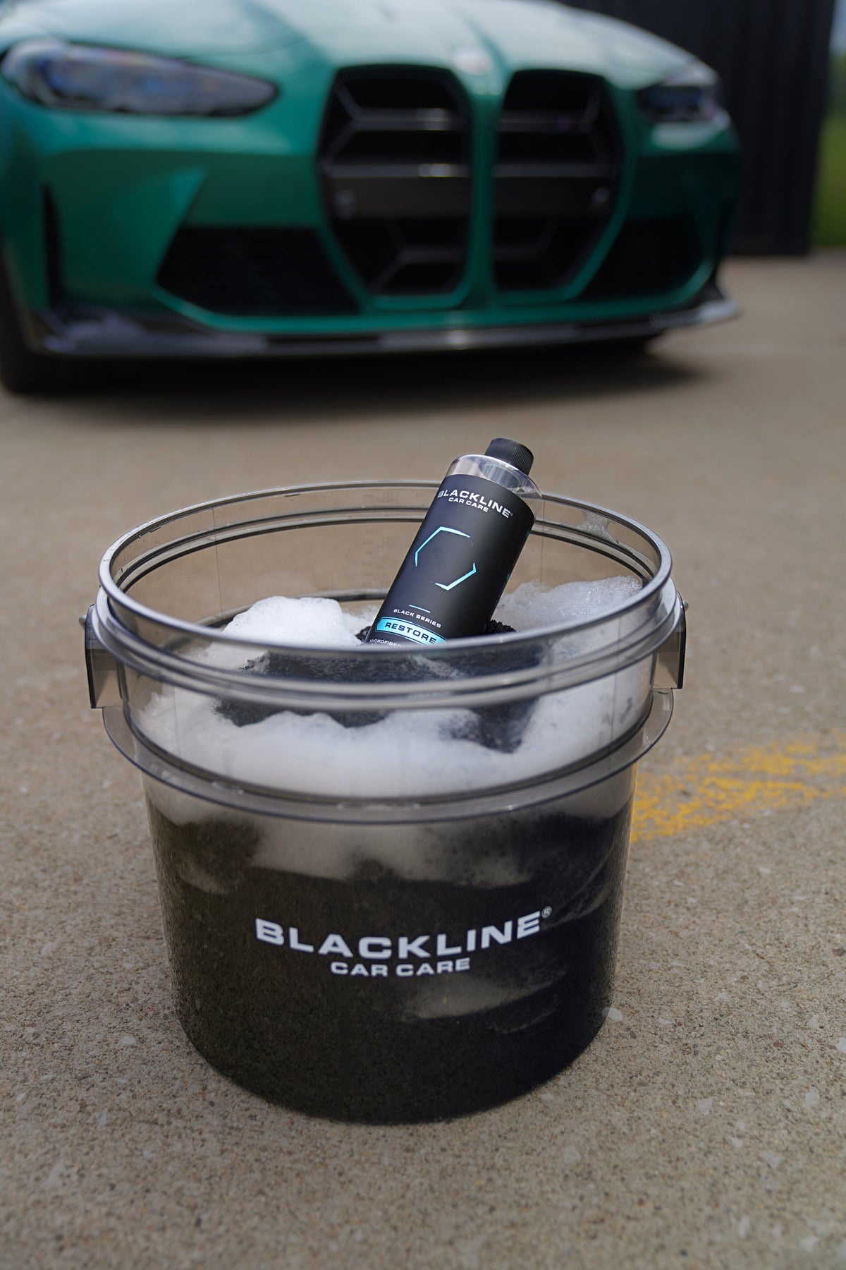 BLACKLINE RESTORE MICROFIBER DETERGENT bottle in bucket, black bottle with blue accents on Tampa Home & Garden Store