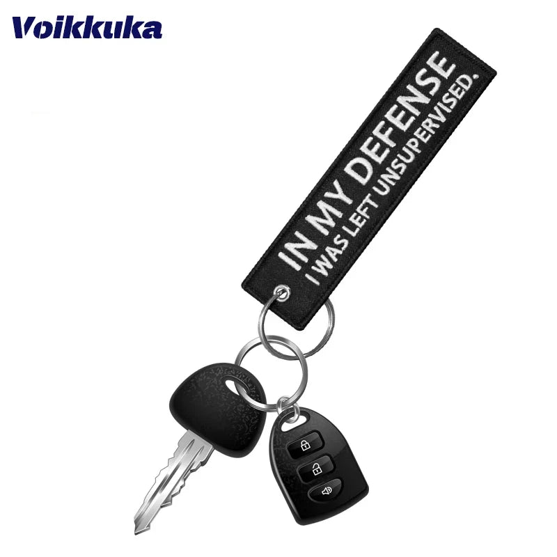 Left Unsupervised Motorcycle Keychain with black fabric strap and metal key and car fob on Tampa Home & Garden Store