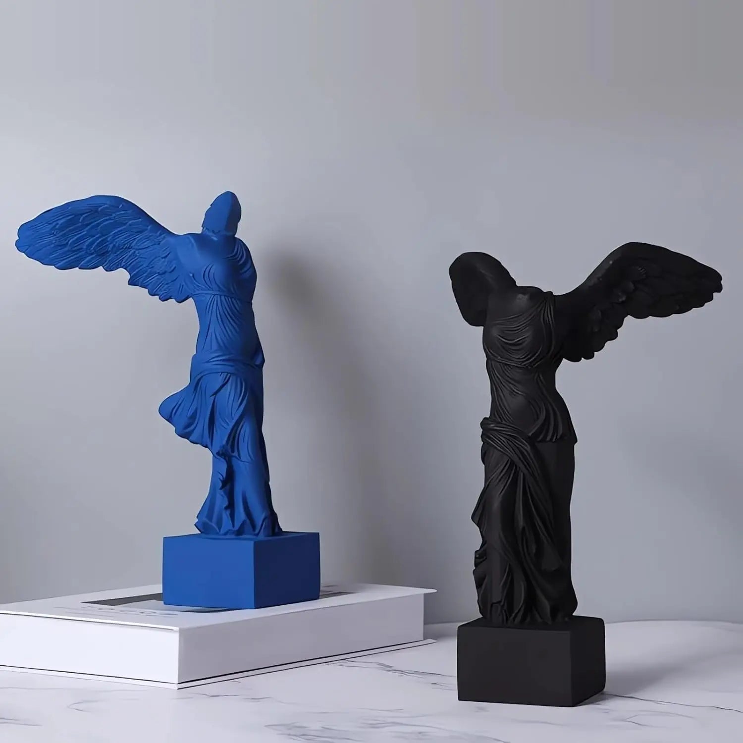 Winged Victory goddess statues, resin decor; blue and black pair on pedestals Perfecsy on Tampa Home & Garden Store