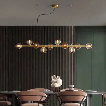 DecorBites LED pendant chandelier with brass bar and glass globes over a modern dining room on Tampa Home & Garden Store
