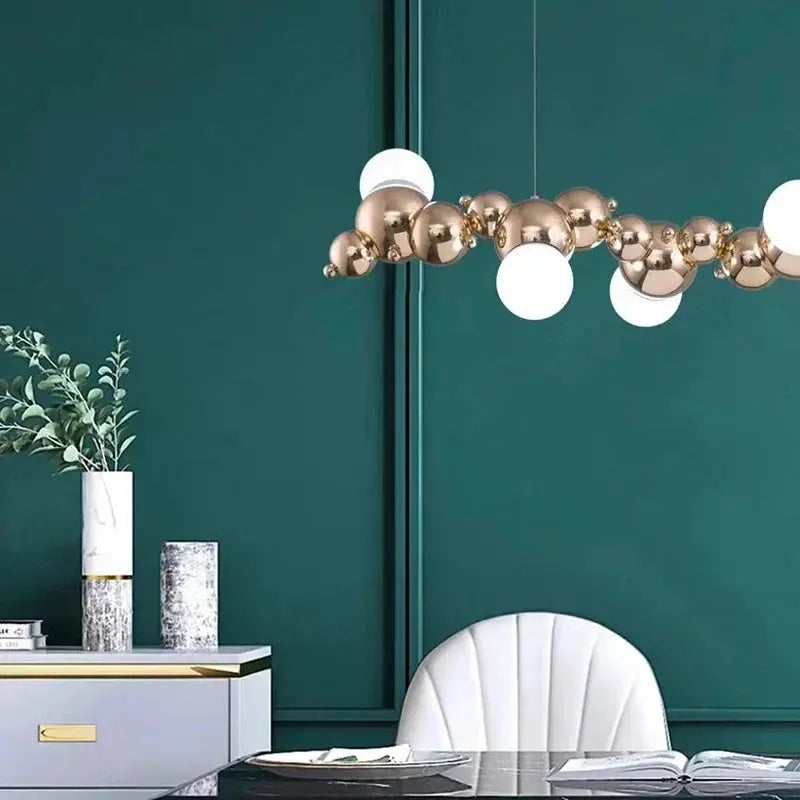 DecorBites LED Pendant Chandeliers with brass orbs and white globes above teal dining space on Tampa Home & Garden Store
