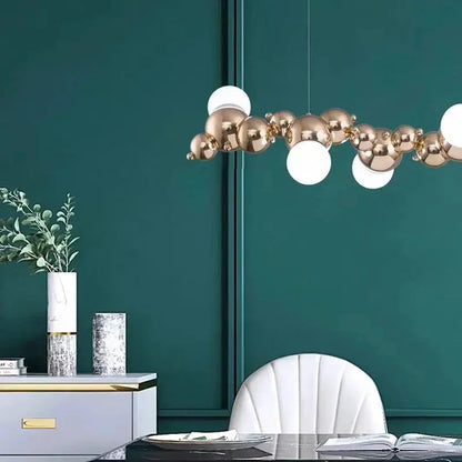 DecorBites LED Pendant Chandeliers with brass orbs and white globes above teal dining space on Tampa Home & Garden Store