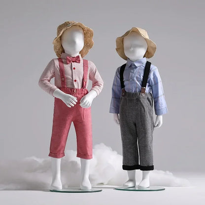 DecorBites two child mannequins in pink suspenders and bow, and blue shirt with gray suspenders on Tampa Home & Garden Store
