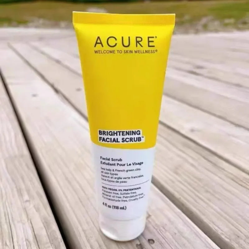 ACURE Brightening Facial Scrub in a yellow tube with black logo on a wooden deck on Tampa Home & Garden Store