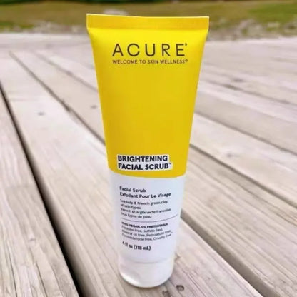 ACURE Brightening Facial Scrub in a yellow tube with black logo on a wooden deck on Tampa Home & Garden Store