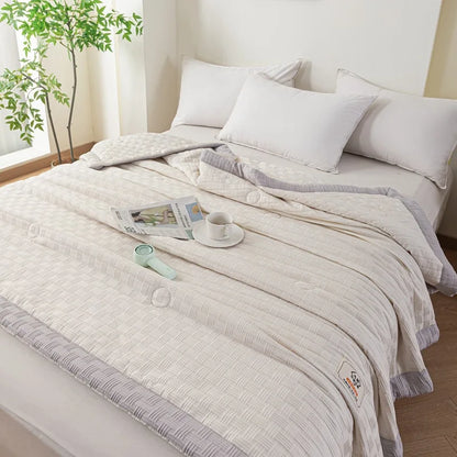 DecorBites knitted waffle summer quilt in light beige with gray border on a bed on Tampa Home & Garden Store