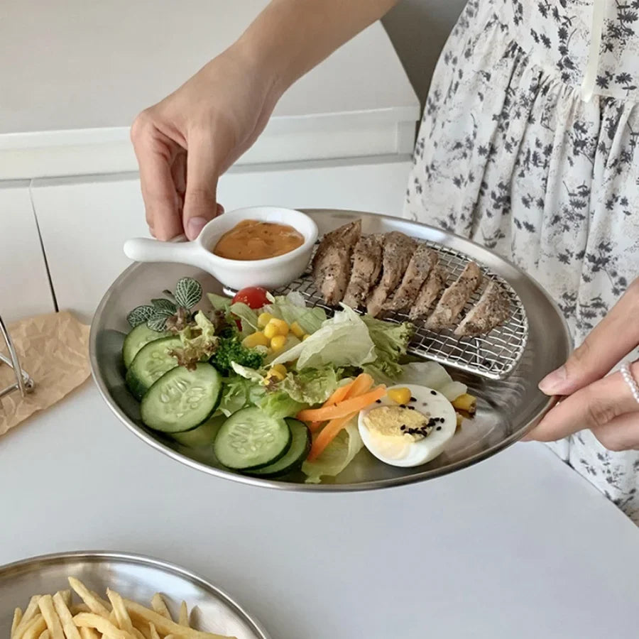 Perfecsy stainless steel round serving plate with grill rack, holding sliced meat and cucumber salad on Tampa Home & Garden Store